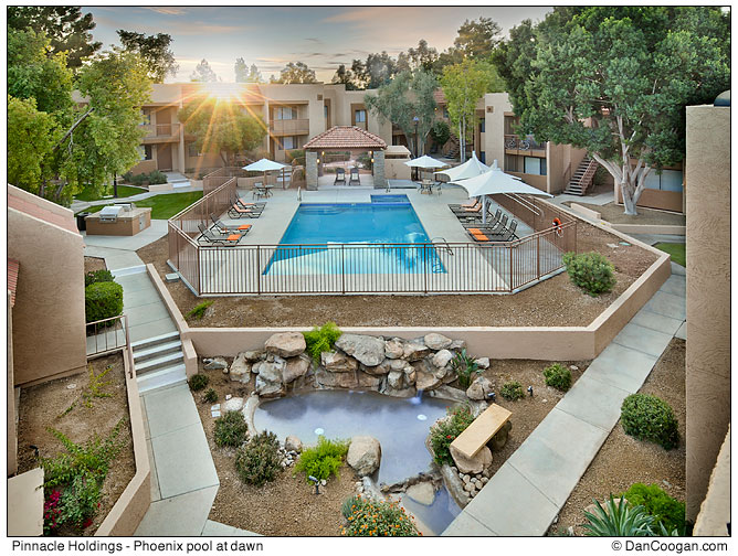 Sun rising above an apartment complex swimming pool at dawn, Phoenix, AZ