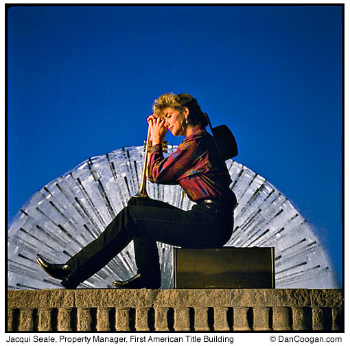 Jacqui Seale, Property Manager, First American Title Building, in front of a fountain with her trumpet