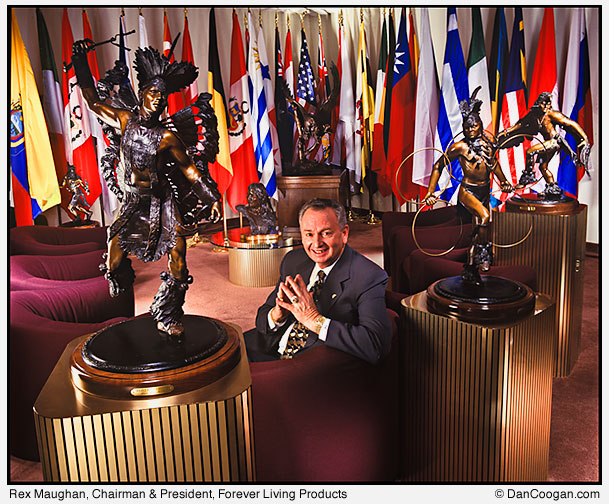 Rex Maughan, Chairman & President, Forever Living Products sitting in front of many flags