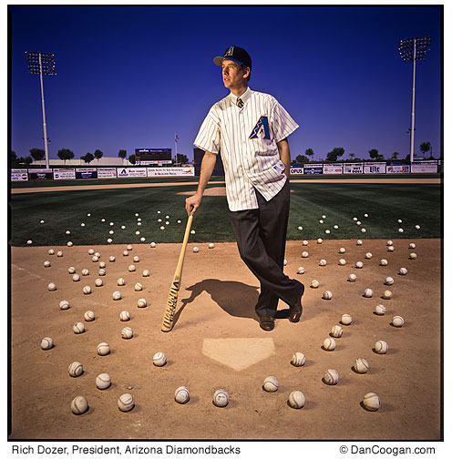 Rich Dozer, President, Arizona Diamondbacks, standing on a baseball field with baseballs all over the ground